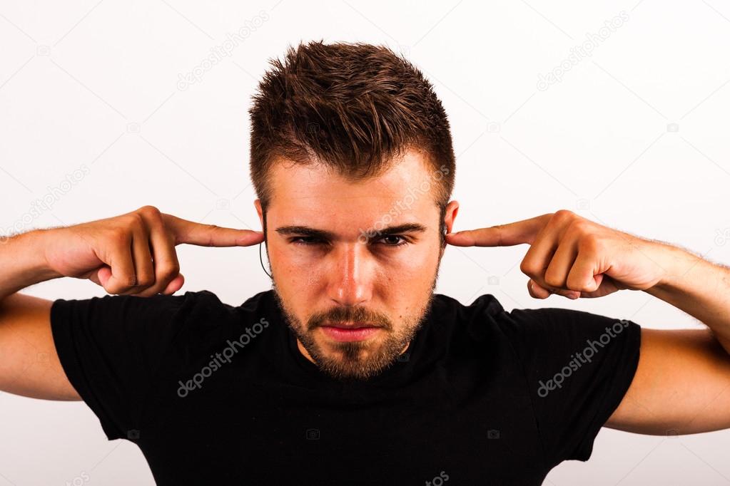 Young man puts fingers in his ears