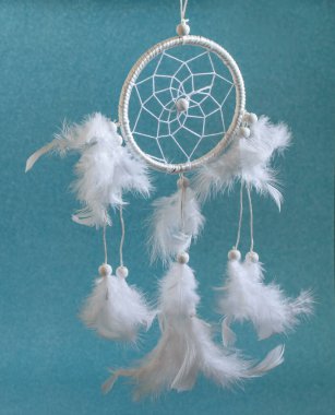 Mavi arka planda tüyleri olan beyaz, sihirli tekerlek dümencisi. Amerikan yerlilerinin, Hint mirasının ve modern iç dekorasyonun etnik tılsımı.. 