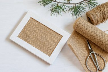 Ortasında çuval bezi olan el yapımı ahşap çerçeve. Çuval bezi, halat ve makas Diy için masaya. Sıfır atık ev içi, plastiksiz yaşam tarzı, maket fotoğraf.