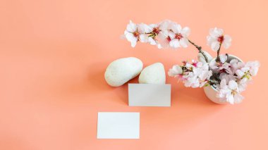 Bahar şablonu kartvizitlerle, badem çiçekli dallarla ve beyaz taşlarla süslenir. Metnin, logon, markan ya da kart üzerindeki herhangi bir bilgi için alanı olan pembe pankart arkaplanı. 