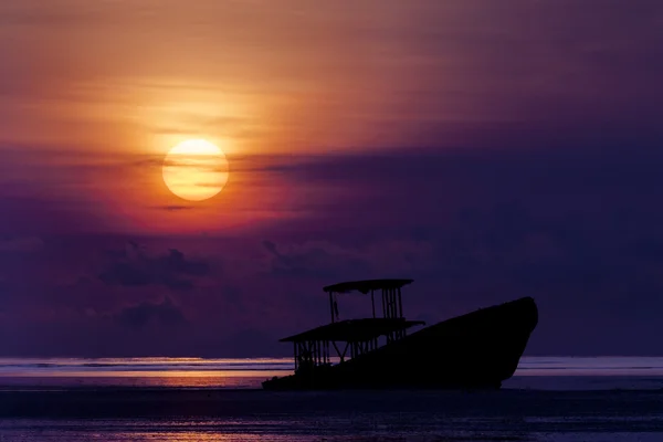 Barco naufragar na praia ao nascer do sol ou pôr do sol . — Fotografia de Stock