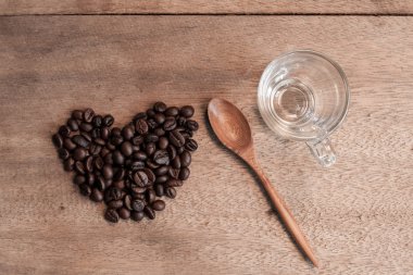 Kahve çekirdekleri ve ahşap arka plan bambu kaşık.