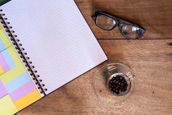 Taza de café en la mesa con diario y vasos . —  Fotos de Stock