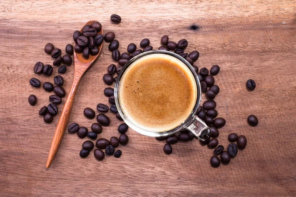 Granos de café y cuchara de bambú sobre fondo de madera . —  Fotos de Stock