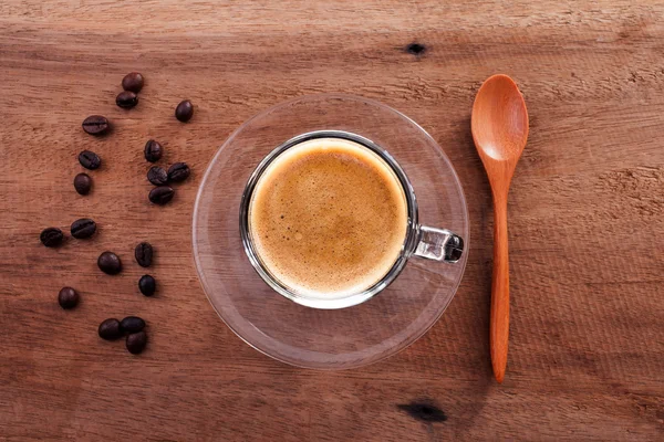 Granos de café y cuchara de bambú sobre fondo de madera . —  Fotos de Stock