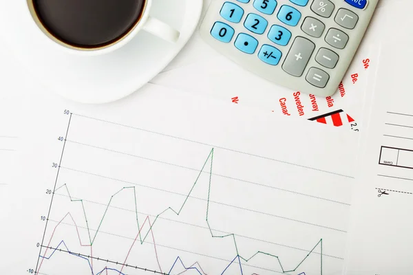 Cup of black coffee and calculator over some financial documantation - close up studio shot — Stock Photo, Image
