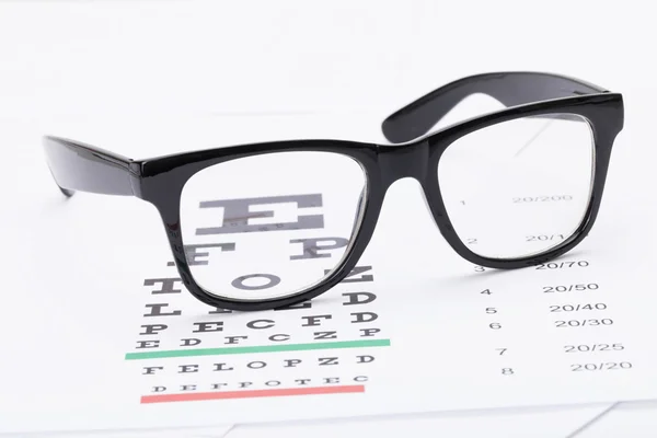 Stół do badań wzroku i okulary schludny nad nim - z bliska strzał studio — Zdjęcie stockowe