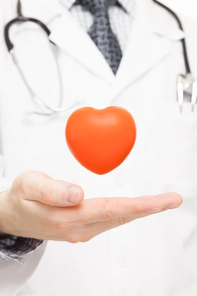 Cuore del giocattolo sul palmo del medico come simbolo dell'assistenza sanitaria — Foto Stock