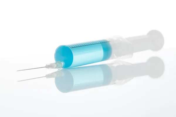 Medical syringe with blue solution inside - studio shot — Stock Photo, Image