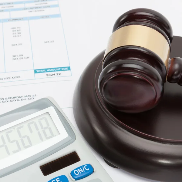 Unpaid bill with calculator and wooden gavel over it series - close up studio shot — Stock Photo, Image