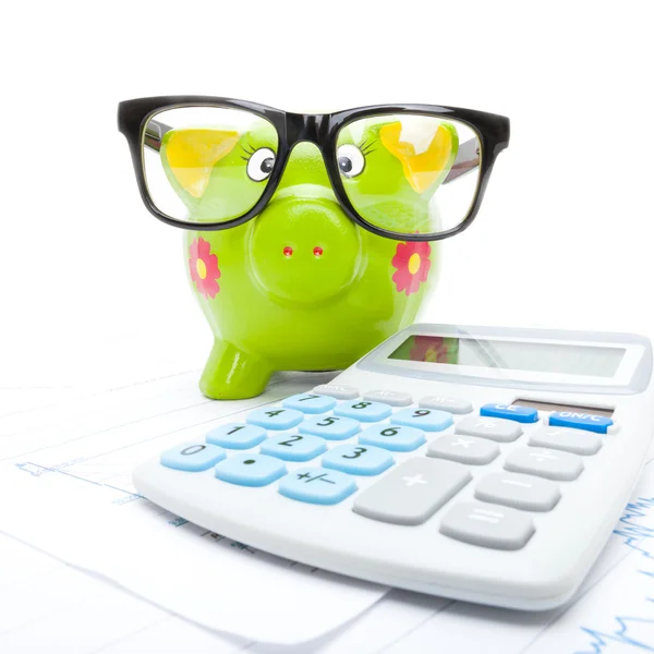 Close up studio shot of a stock market chart with piggy bank and calculator over it — Stock Photo, Image