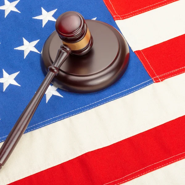 Close up studio shot of a wooden judge gavel and soundboard laying over US flag — Stock Photo, Image