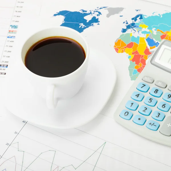 Close up shot of a coffee cup and calculator over world map and some documents — Stock Photo, Image