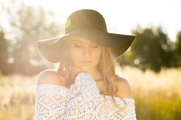 Beautiful young lady model posing in a field at sunrise - outdoors shoot — Stock Photo, Image