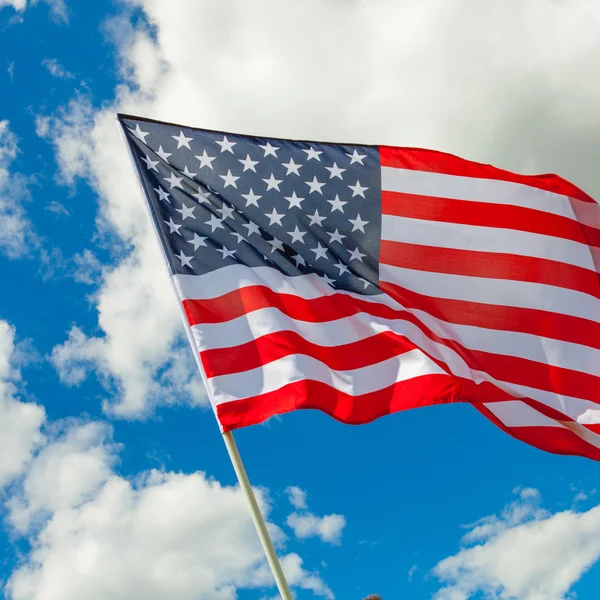 Bandeira do EUA com céu azul e nuvens por trás — Fotografia de Stock