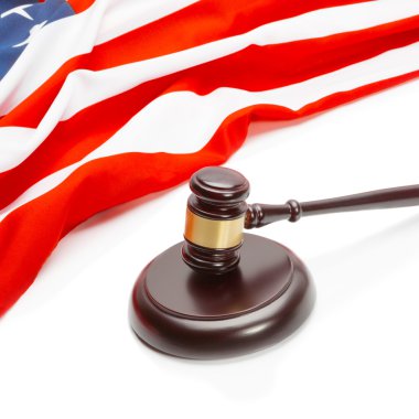 Close up studio shot of wooden judge gavel near flag of Unites States of America