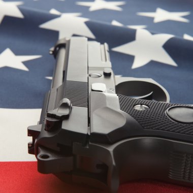 Close up studio shot of a national flag with a hand gun over it series - United States