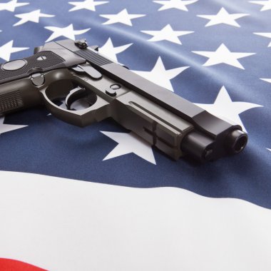 Close up of a ruffled national flag with hand gun over it series - USA