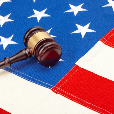 Close up studio shot of a judge gavel over US flag