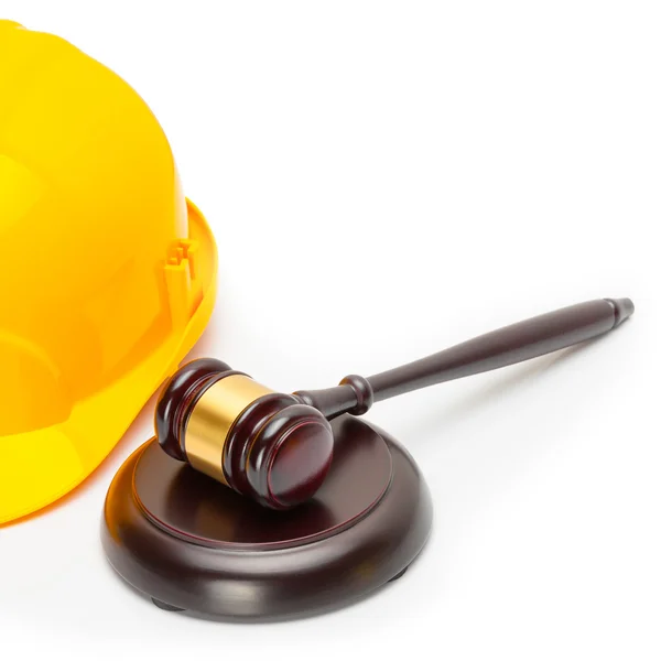 Close up studio shot of a wooden judge gavel with yellow protective helmet — Stock Photo, Image