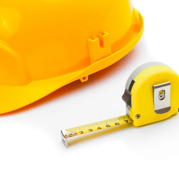 Close up studio shot of a construction helmet with measure tape on white — Stok fotoğraf