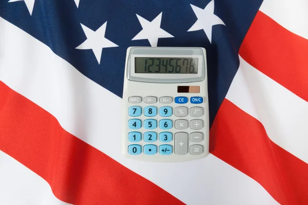 Tiro de estúdio de babados bandeira nacional com calculadora sobre ele - U Fotos De Bancos De Imagens