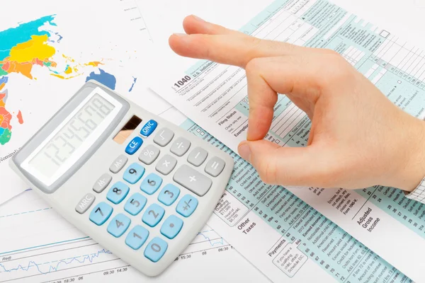 Hombre mostrando Ok firmar sobre 1040 nos Tax Form - foco en calculadora — Foto de Stock