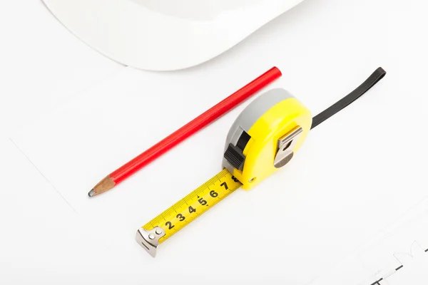 White construction helmet with pencil and measure tape near it — Stock Photo, Image
