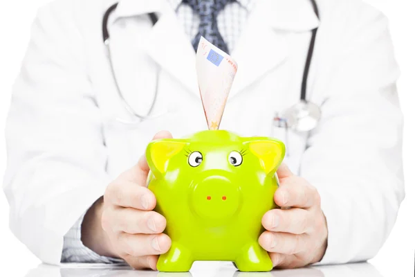 Доктор Холдинг piggy банка как идея экономии для медицинских расходов Стоковая Картинка