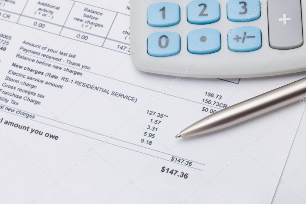 Studio shot of calculator and pen over some receipt under it - focus on pen