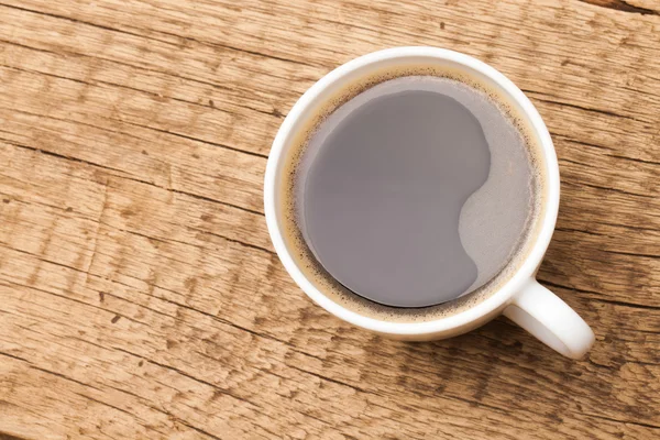 Koffie in witte keramische cup op houten tafel — Stockfoto