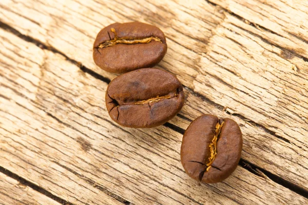 Roasted coffee beans on old wooden table — Stock Photo, Image