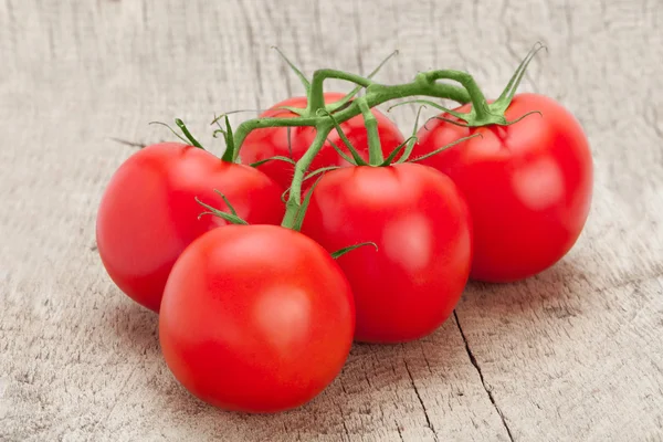 Bunch of fresh tomatoes on old wooden table — Stock Photo, Image