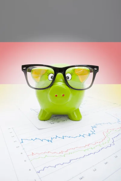 Piggy bank over stock market chart with German flag on background - part of series — Stock Photo, Image