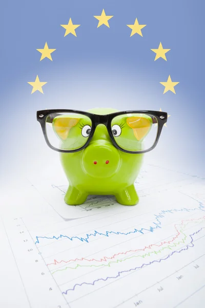 Salvadanaio sul grafico del mercato azionario con bandiera europea sullo sfondo - parte della serie — Foto Stock
