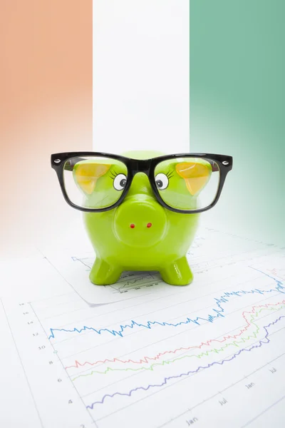 Piggy bank with flag on background - Cote d'Ivoire — Stock Photo, Image