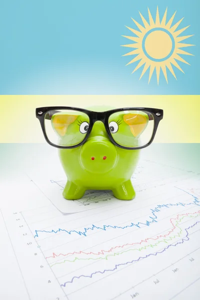 Piggy bank met vlag op achtergrond - rwanda — Stockfoto