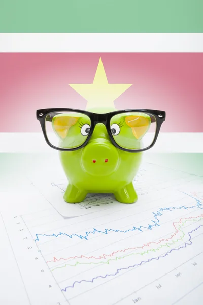Piggy bank met vlag op achtergrond - Republiek suriname — Stockfoto