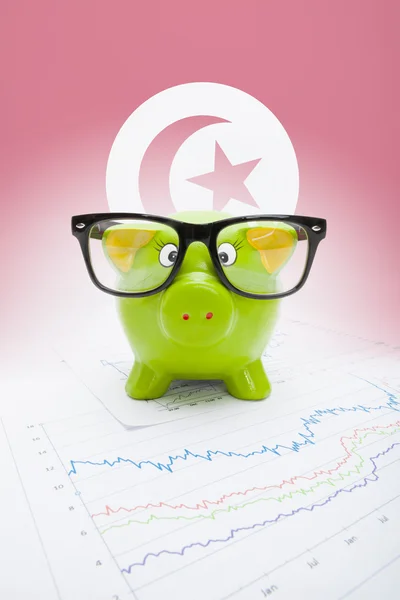 Piggy bank with flag on background - Tunisia — Stock Photo, Image