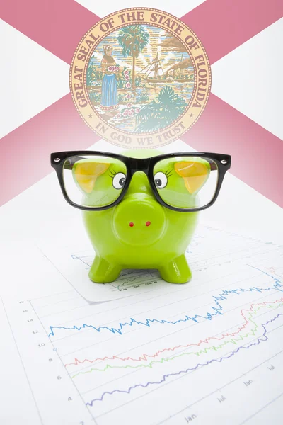 Piggy bank met ons staat vlag op achtergrond - florida — Stockfoto