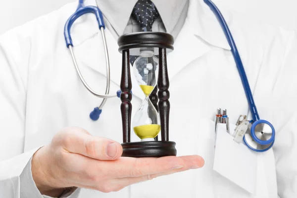 Doctor holdling in his hand a hourglass - heath care concept — Stock Photo, Image