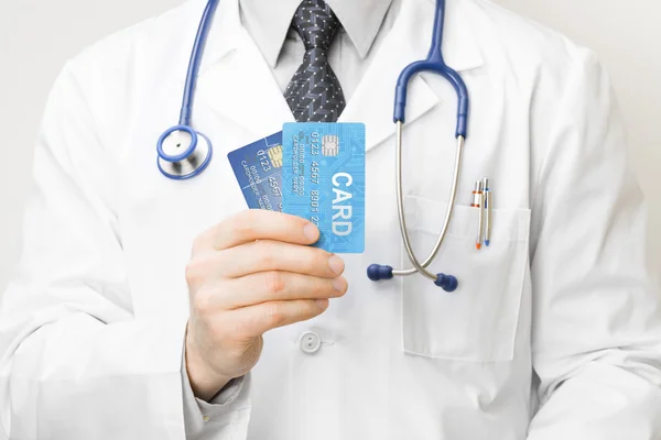 Doctor holding tarjetas de crédito en la mano - closeup studio disparó —  Fotos de Stock