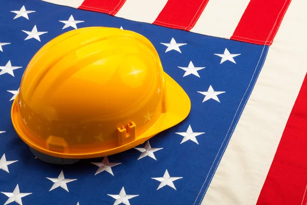 Casco de construcción sobre la bandera de Estados Unidos - closeup disparar — Foto de Stock