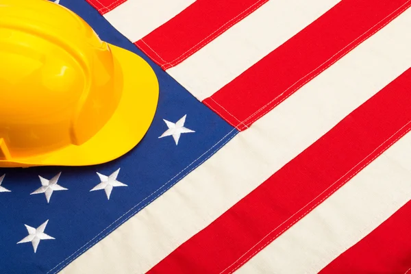 Construction helmet laying over US flag — Stock Photo, Image