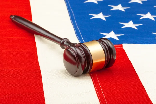 Wooden judge gavel over US flag - closeup studio shot — Stock Photo, Image