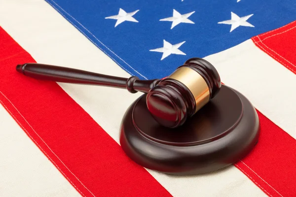 Wooden judge gavel and soundboard laying over USA flag - closeup shot — Stock Photo, Image