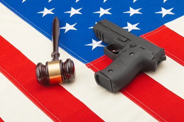 Wooden judge gavel and gun over USA flag - studio shot — Stock Photo, Image