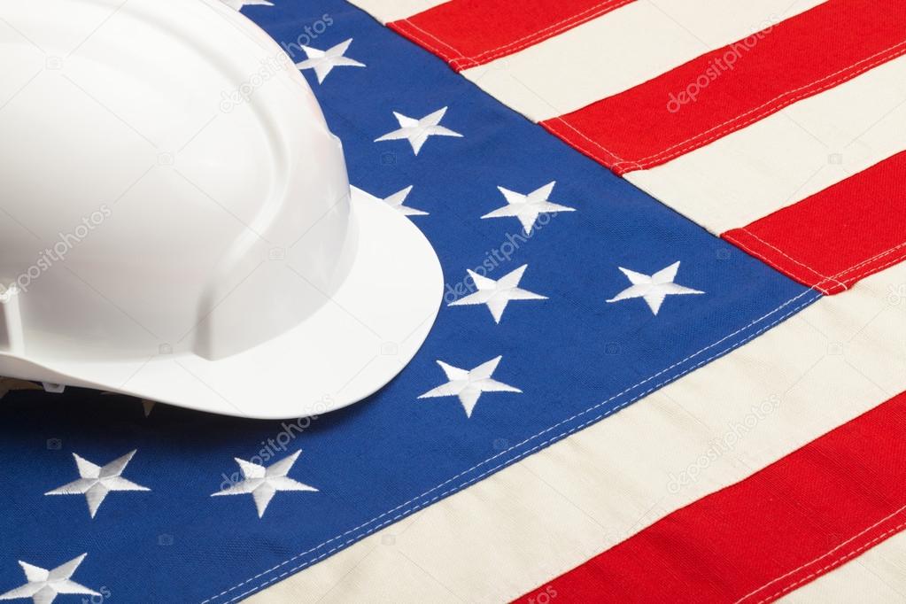 White color construction helmet laying over USA flag - closeup shoot