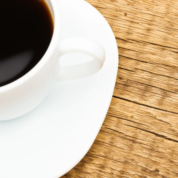 Close up of white ceramic coffee cup on wooden table - studio shot - 1 to 1 ratio — Stock Photo, Image