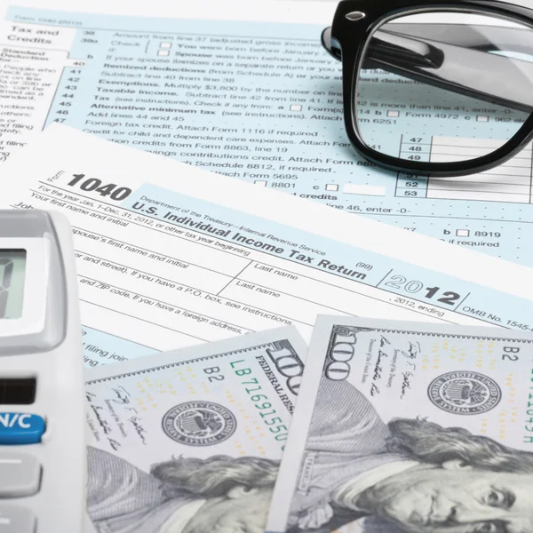 Modulo fiscale di USA 1040 con occhiali, calcolatrice e 100 US Dollaro - rapporto 1: 1 — Foto Stock